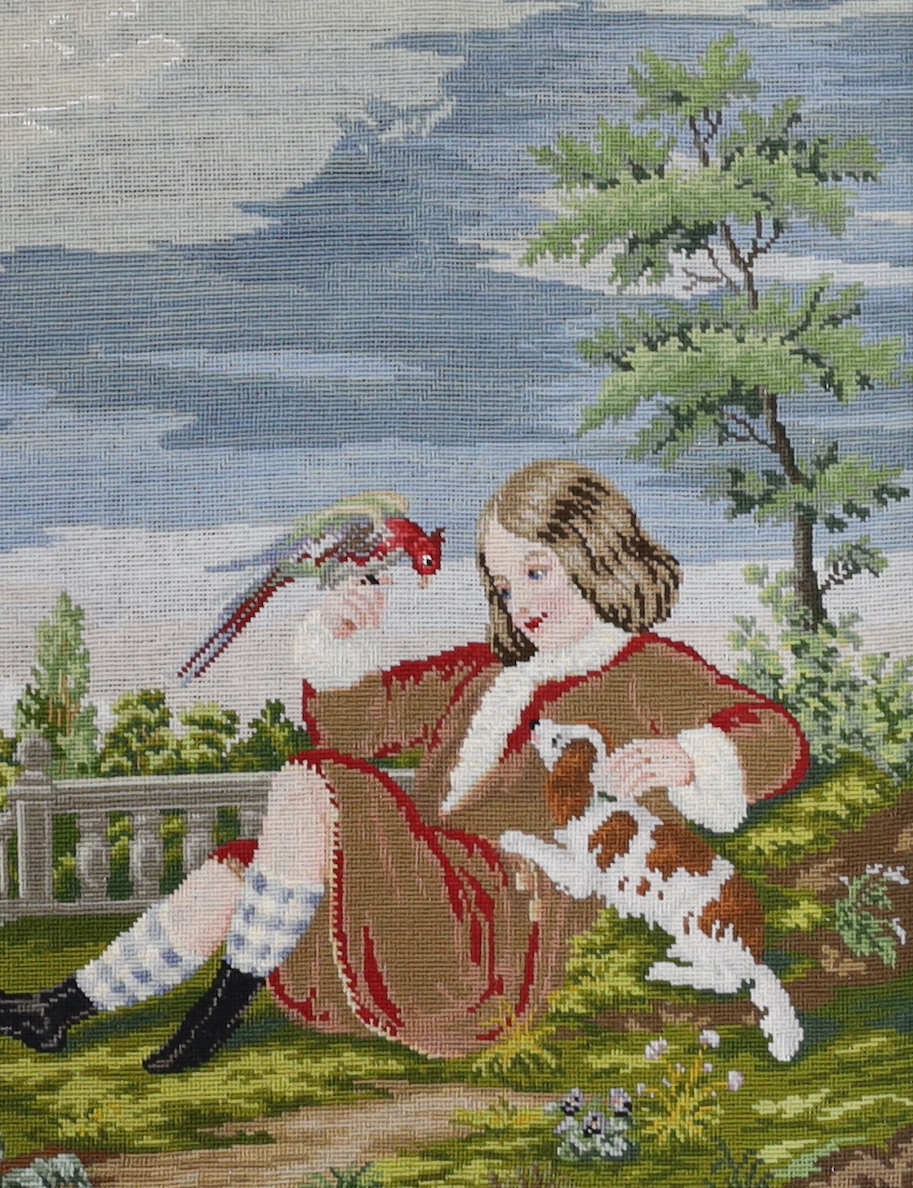 A framed Victorian Berlin needlework panel, of the Duke of Northumberland as a boy of 12 years (in 1751) holding a pet parrot and King Charles Spaniel, label verso, 26cm wide x 34cm high